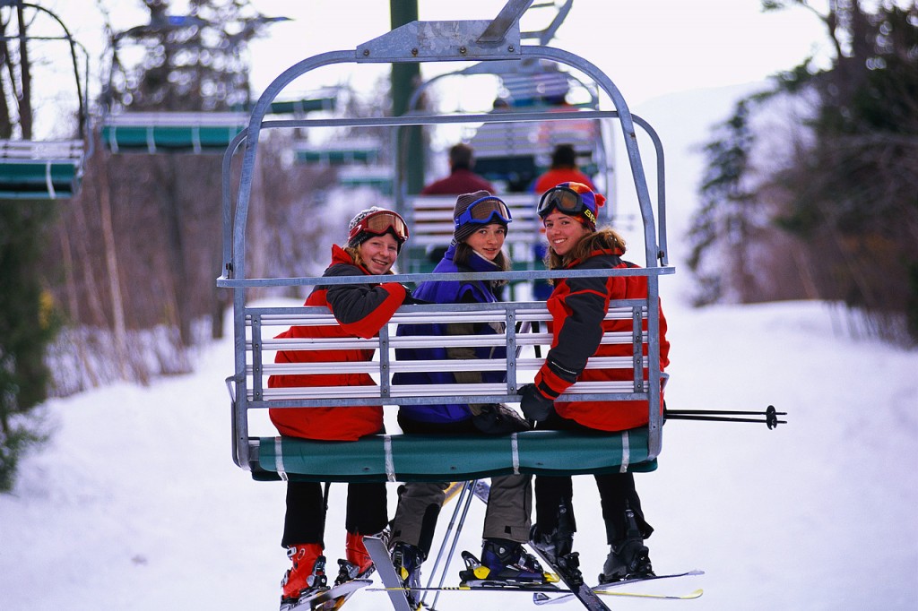 Skiers Riding a Chair Lift